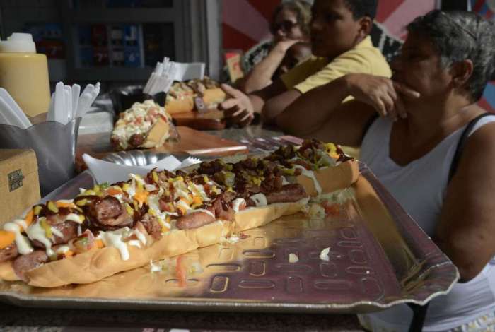Versões gigantes de sanduíche de pão com linguiça na Feira Nacional do Podrão, que reúne opções de lanches e gastronomia popular de rua no Terreirão do Samba, no centro da cidade. - Fernando Frazão/Agência Brasil