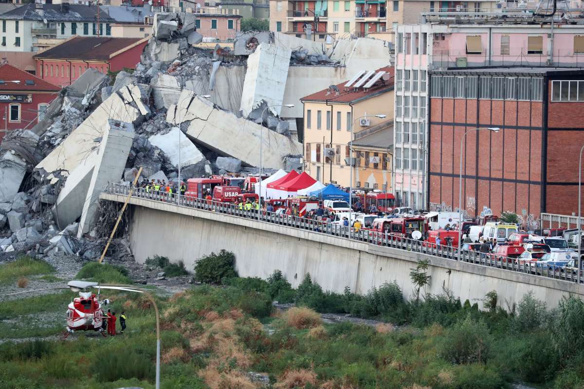 A general view of rescuers at the scene of the collapsed Morandi motorway bridge in the northwestern city of Genoa on August 14, 2018.
About 30 people were killed when a giant motorway bridge collapsed in heavy rain in the Italian city of Genoa in what the government called an "immense tragedy". The collapse, which saw a vast stretch of the A10 freeway tumble on to railway lines in the northern port city, came as the bridge was undergoing maintenance work and as the Liguria region, where Genoa is situated, experienced torrential rainfall. / AFP PHOTO / Valery HACHE