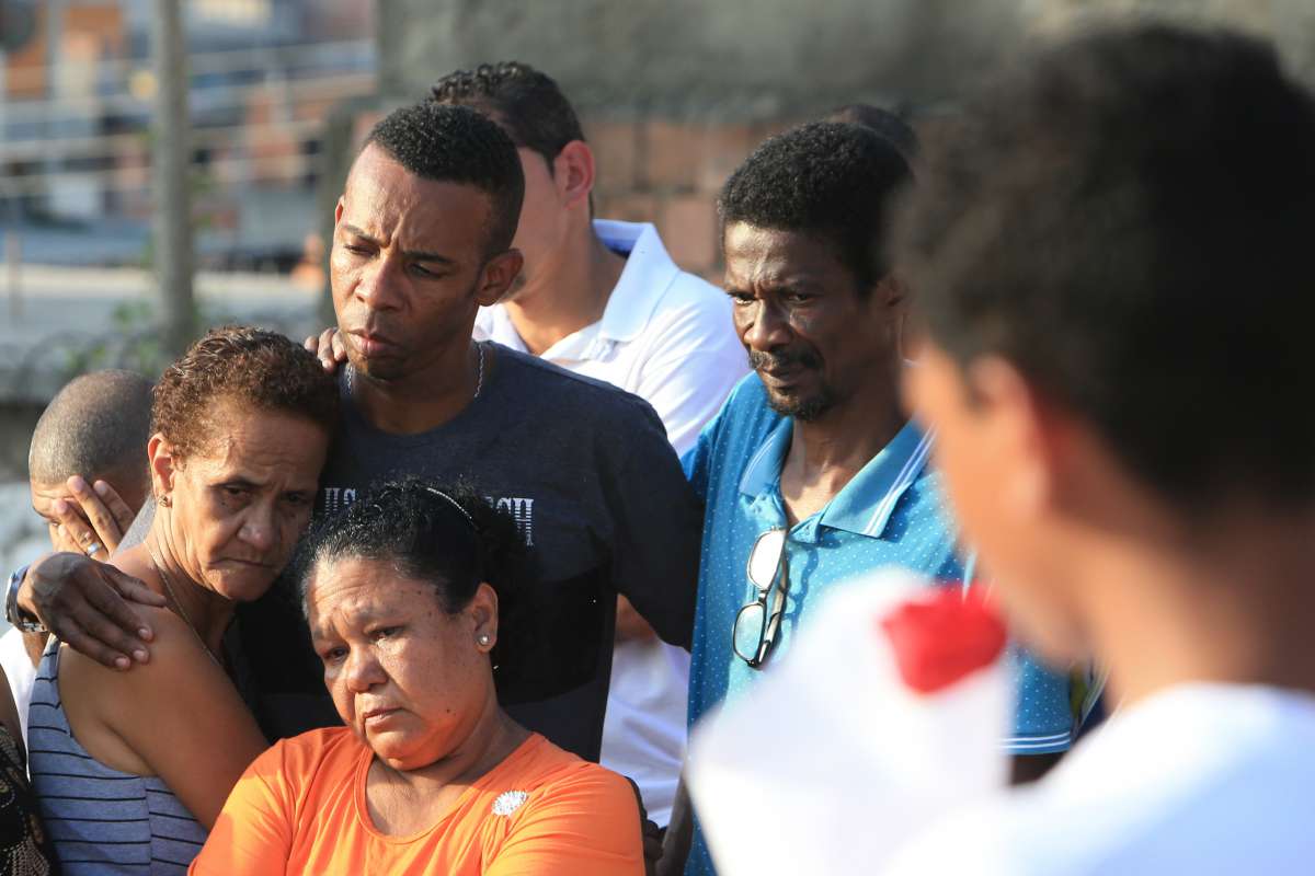 Enterro da costureira V&acirc;nia Silva Tib&uacute;rcio, 36 anos. O viuvo Carlos Alberto Lopes (camisa cinza com uma faixa preta) com sua m&atilde;e e seu pai.  Ela  foi baleada por um policial militar em uma blitz (20) &agrave; noite, em Duque de Caxias, na Baixada Fluminense. A costureira estava passando de carro com o marido, pela Avenida Presidente Kennedy, e os dois foram abordados pela pol&iacute;cia. O enterro aconteeu no Cemit&eacute;rio Nossa Senhora das Gra&ccedil;as no Tanque do Anil em Duque de Caxias, Rio de Janeiro. Foto: Daniel Castelo Branco / Ag&ecirc;ncia O Dia