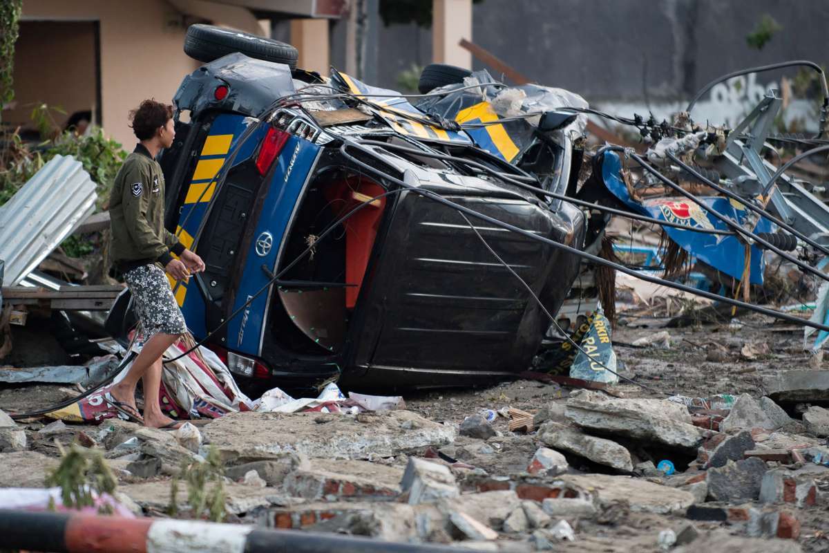 A man looks for belongings from his house after it was damaged in Palu in Central Sulawesi on September 29, 2018, following a strong earthquake and tsunami that struck the area.
Nearly 400 people were killed when a powerful quake sent a tsunami barrelling into the Indonesian island of Sulawesi, officials said on September 29, as hospitals struggled to cope with hundreds of injured and rescuers scrambled to reach the stricken region. / AFP PHOTO / Bay ISMOYO
      Caption