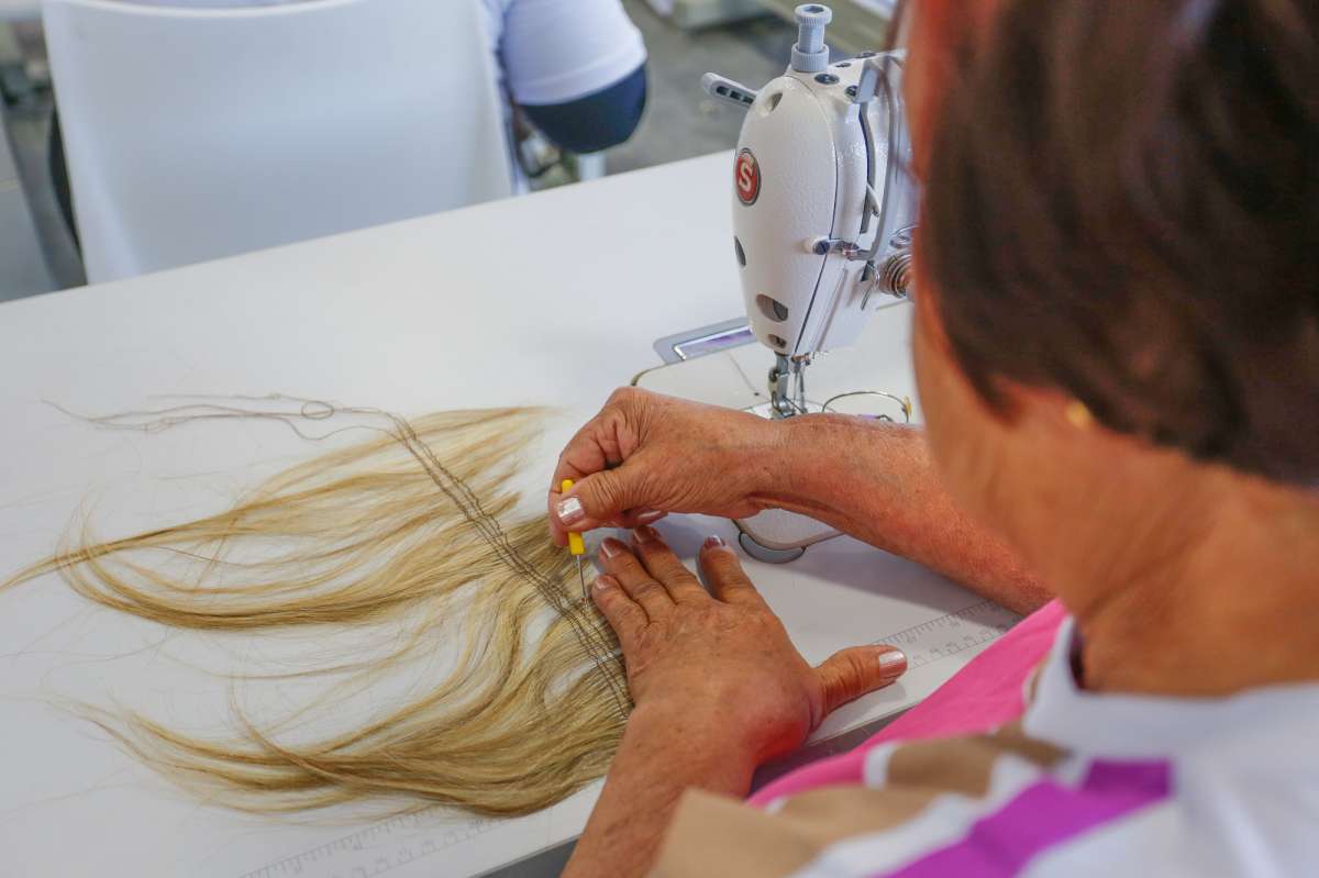 Projeto Força na Peruca, da Fundação Laço Rosa, qualifica jovens de comunidades carentes para a fabricação do acessório. Parte do que produzem é doado para a fundação - Divulgação