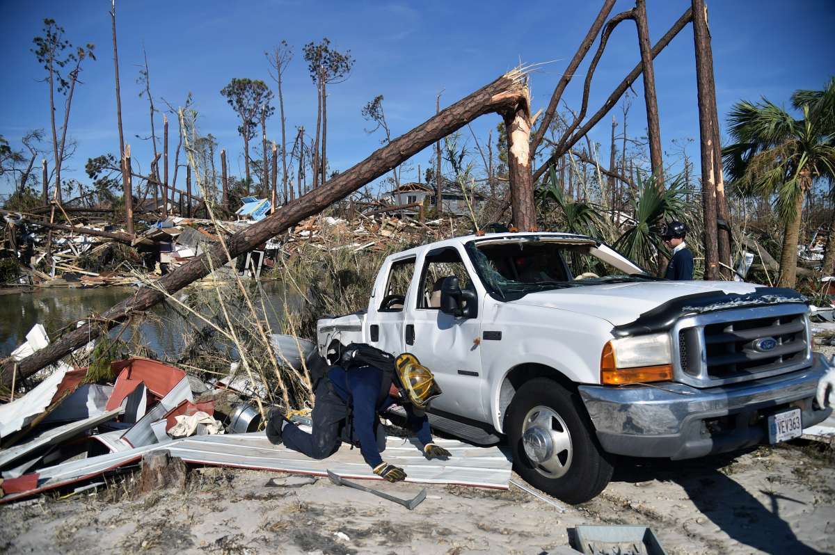 Utility workers repair power lines in the aftermath of Hurricane Michael in Panama City, Florida on October 12, 2018. - Rescue teams using sniffer dogs carried out a grim search for victims of Hurricane Michael on Friday amid fears that the death toll from the monster storm, which currently stands at 11, could rise. (Photo by Brendan Smialowski / AFP)
      Caption