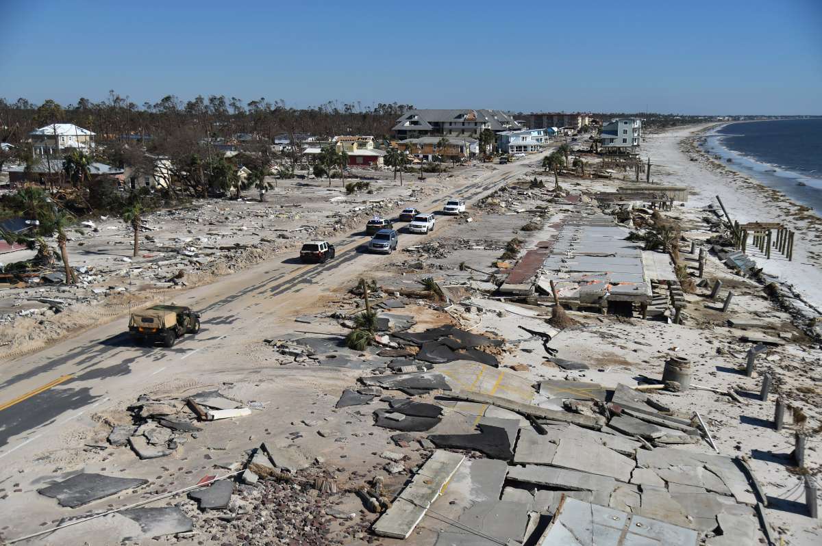 Utility workers repair power lines in the aftermath of Hurricane Michael in Panama City, Florida on October 12, 2018. - Rescue teams using sniffer dogs carried out a grim search for victims of Hurricane Michael on Friday amid fears that the death toll from the monster storm, which currently stands at 11, could rise. (Photo by Brendan Smialowski / AFP)
      Caption