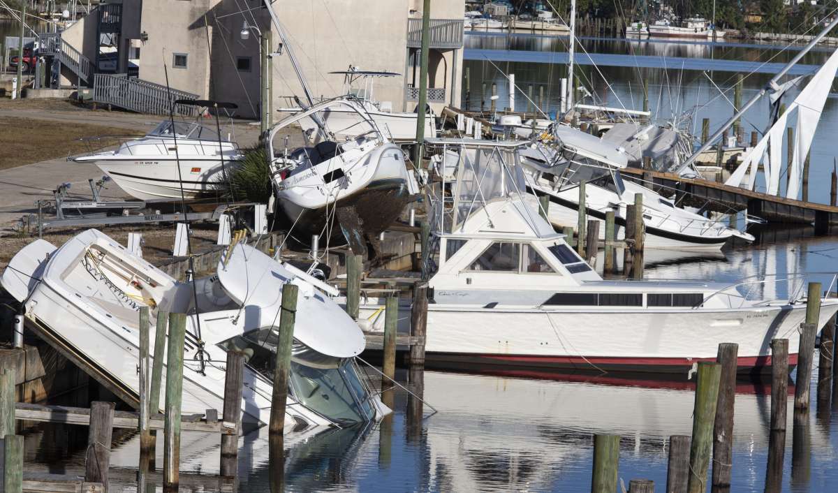 Utility workers repair power lines in the aftermath of Hurricane Michael in Panama City, Florida on October 12, 2018. - Rescue teams using sniffer dogs carried out a grim search for victims of Hurricane Michael on Friday amid fears that the death toll from the monster storm, which currently stands at 11, could rise. (Photo by Brendan Smialowski / AFP)
      Caption