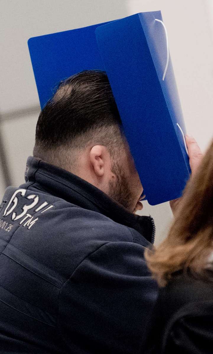 Niels Hoegel se esconde atrás de uma pasta quando chega ao tribunal, em Oldenburg, no norte da Alemanha, para o início de seu julgamento (Julian Stratenschulte / POOL / AFP)