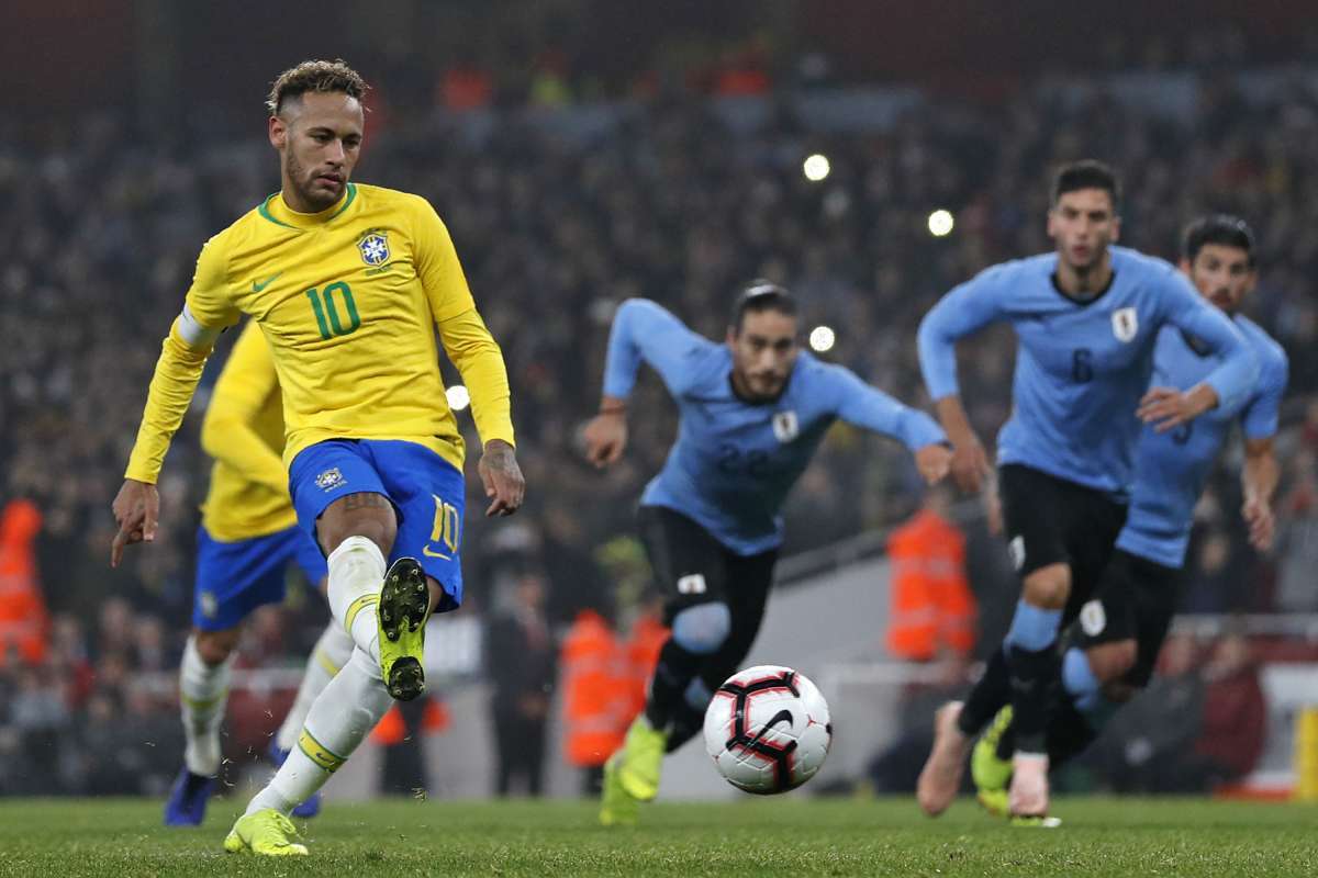 Brazil's striker Neymar (L) scores the opening goal from the penalty spot during the international friendly football match between Brazil and Uruguay at The Emirates Stadium in London on November 16, 2018. (Photo by Adrian DENNIS / AFP)