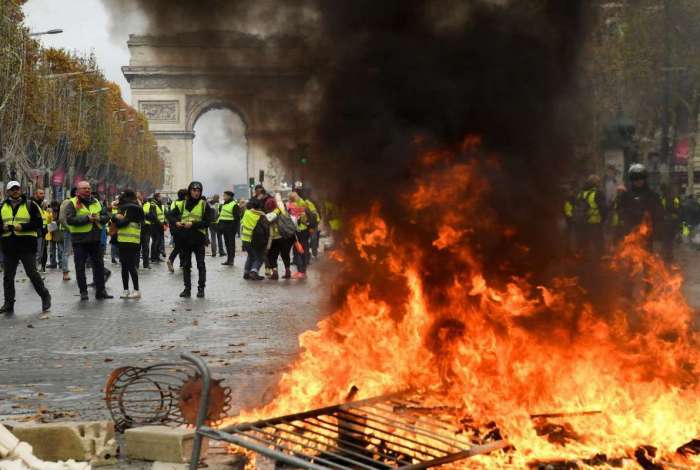 Manifestantes durante um protesto dos 'coletes amarelos' contra o aumento dos preços do combustível e do custo de vida perto do Arco do Triunfo, em Paris (Bertrand Guay /AFP)