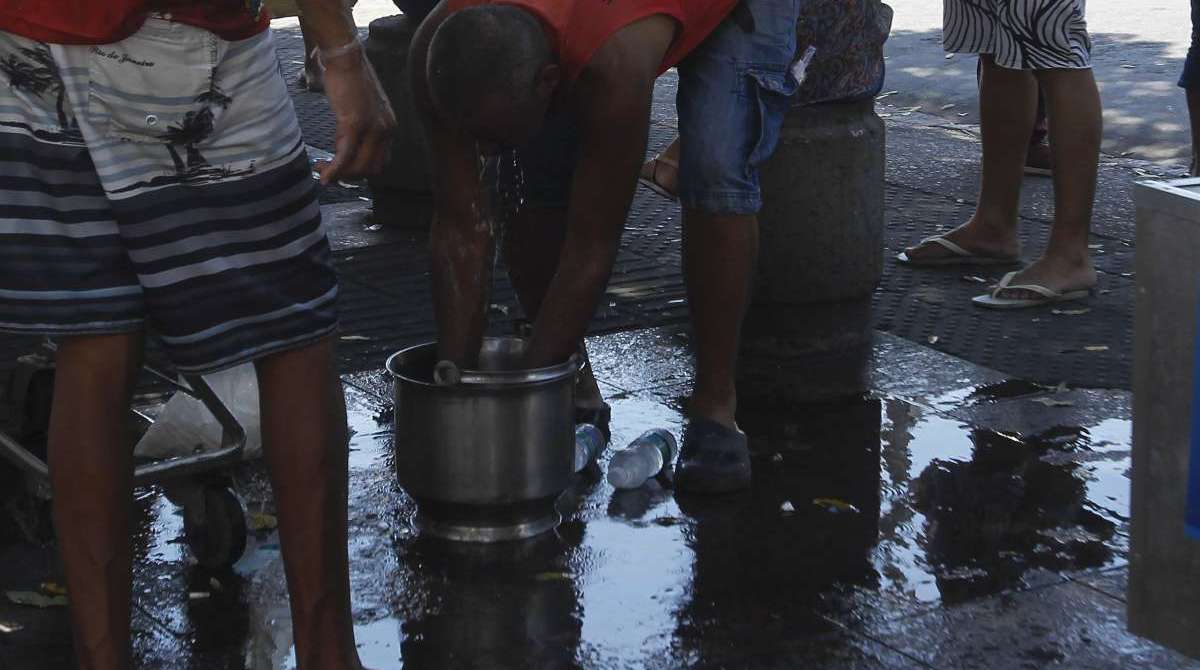 O ambulante Jo&atilde;o Pinto se refresca no balde de gelo