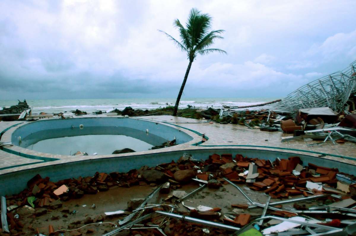 Debris of damaged buildings is seen around a swimming pool near a beach in Anyer, Serang on December 23, 2018, after the area was hit by a tsunami on December 22 following an eruption of the Anak Krakatoa volcano. - A volcano-triggered tsunami has left at least 222 people dead and hundreds more injured after slamming without warning into beaches around Indonesia's Sunda Strait, officials said on December 23, voicing fears that the toll would rise further. (Photo by Dasril Roszandi / AFP)
      Caption