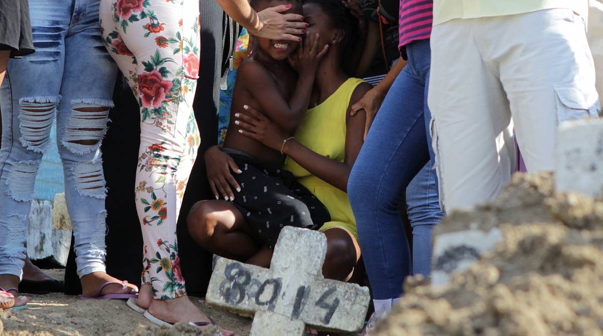O filho caçula de Iolanda foi consolado pelas irmãs durante o enterro  