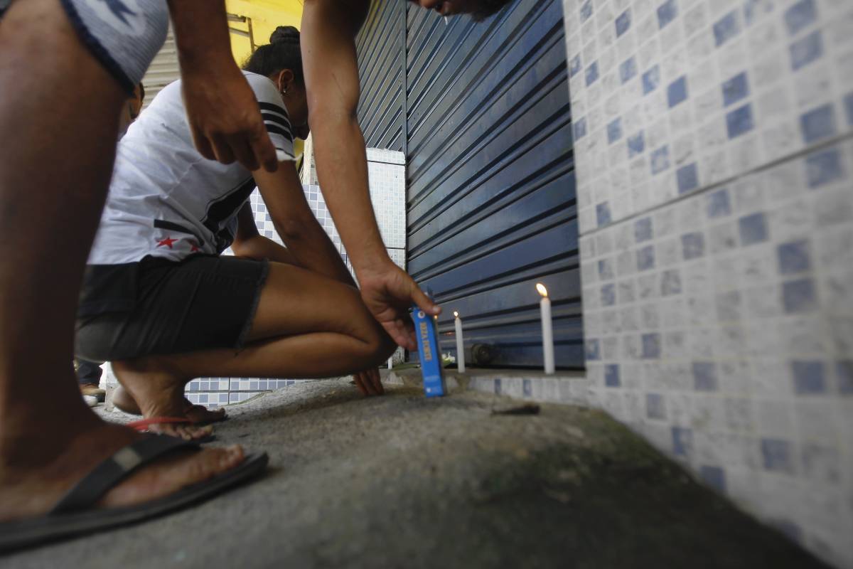 Rio, 16/01/2019 - Amigos acendem velas  na porta do supermercado onde Matheus dos Santos Lessa, 22 anos morreu baleado quando tentava defender a m&atilde;e de bandidos, durante assalto ao estabelecimento de sua fam&iacute;lia, em Guaratiba, na Zona Oeste do Rio  - Foto: Severino Silva/Ag&ecirc;ncia O Dia