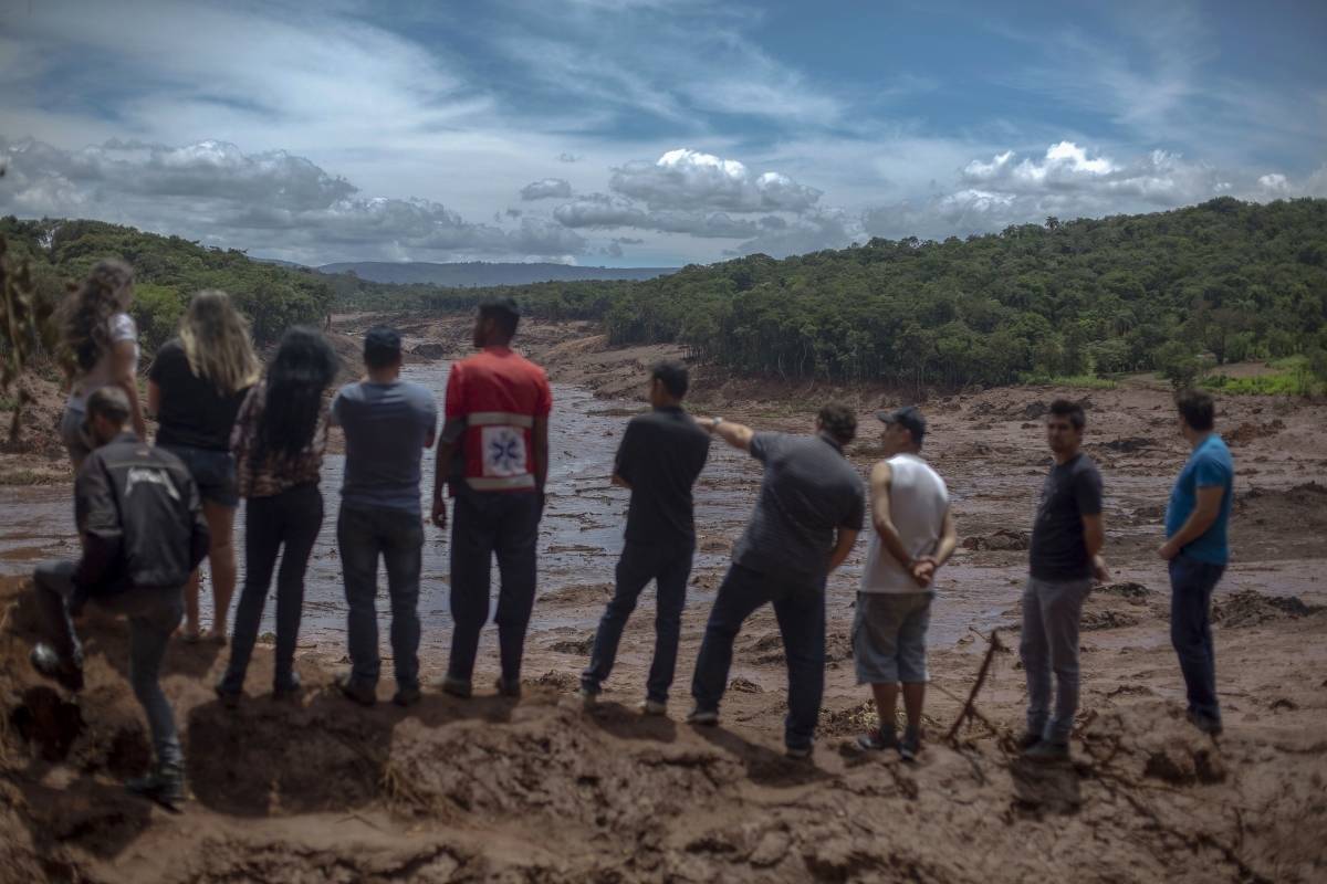 People look at an area in the community of Casa Grande affected by a sludge after the collapse, two days ago, of a dam at an iron-ore mine belonging to Brazil's giant mining company Vale near the town of Brumadinho, state of Minas Gerias, southeastern Brazil, on January 27, 2019. - Communities were devastated by a dam collapse that killed at least 37 people at a Brazilian mining complex -- with hopes fading for 250 still missing. A barrier at the site burst on Friday, spewing millions of tons of treacherous sludge and engulfing buildings, vehicles and roads. (Photo by Mauro PIMENTEL / AFP)