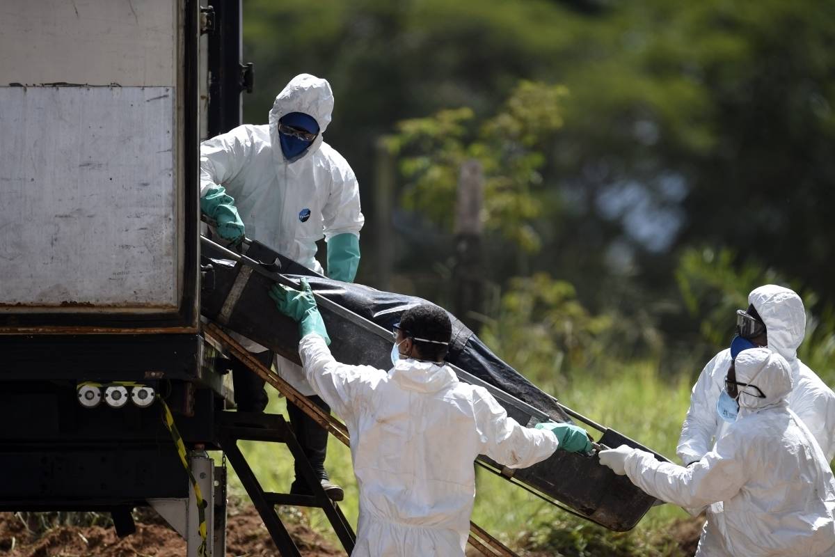Equipes de resgate colocam um corpo recuperado após o colapso da represa de sexta-feira em um caminhão refrigerado em Córrego do Feijao, perto da cidade de Brumadinho