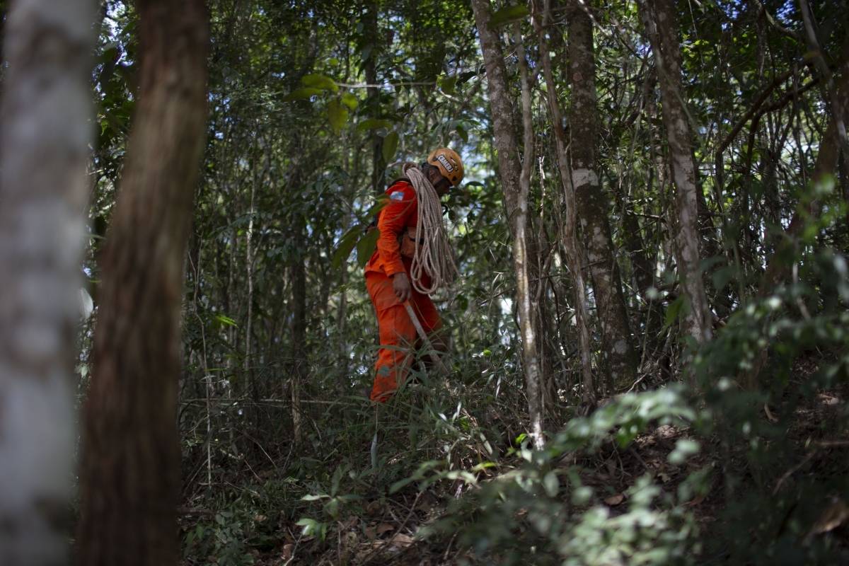 Um bombeiro abre uma rota de fuga durante a busca por vítimas do rompimento da barragem de sexta-feira em uma mina de ferro pertencente à gigante mineradora Vale