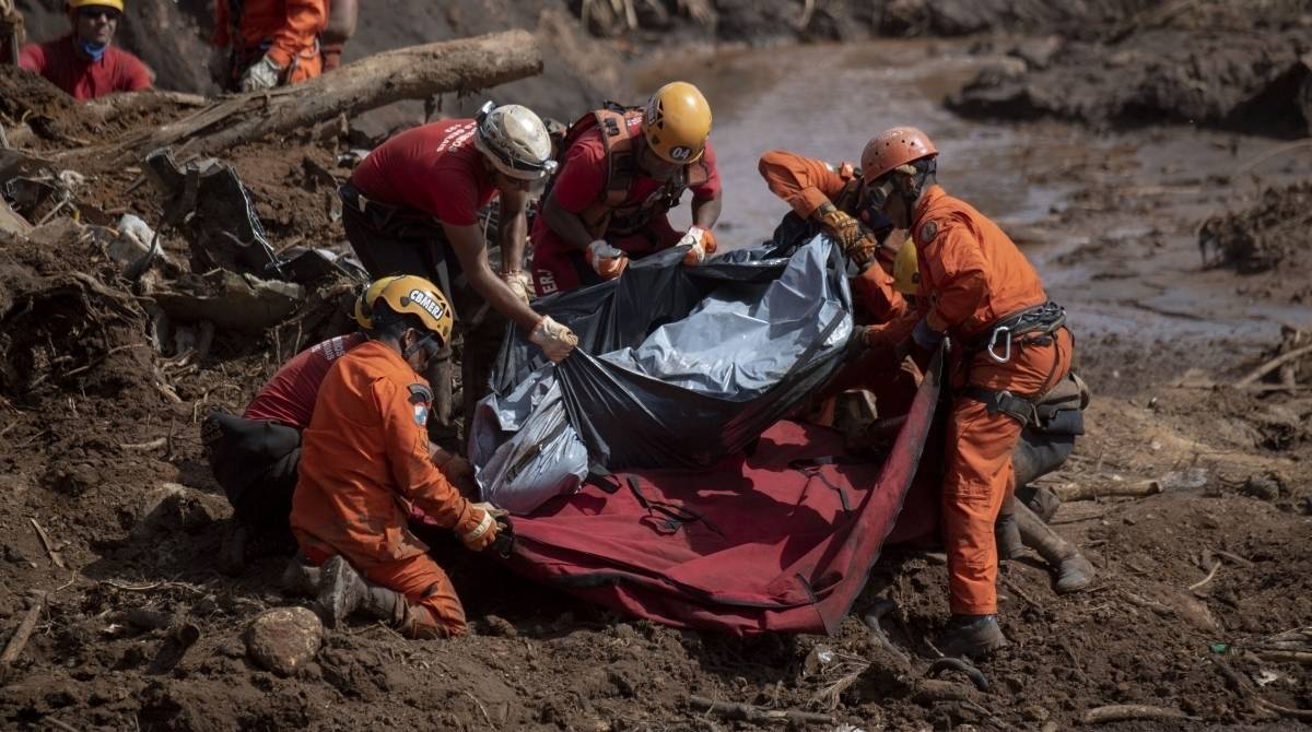 Bombeiros cobrem o corpo de uma v&iacute;tima do rompimento da baragem 1 da Mina Feij&atilde;o, em Brumadinho
