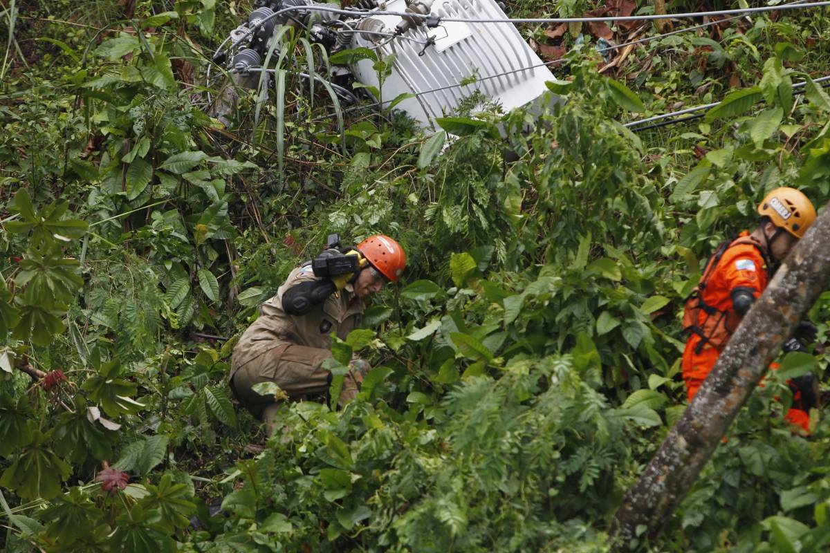 Bombeiros trabalham na retirada de um ônibus que ficou soterrado na Avenida Niemeyer