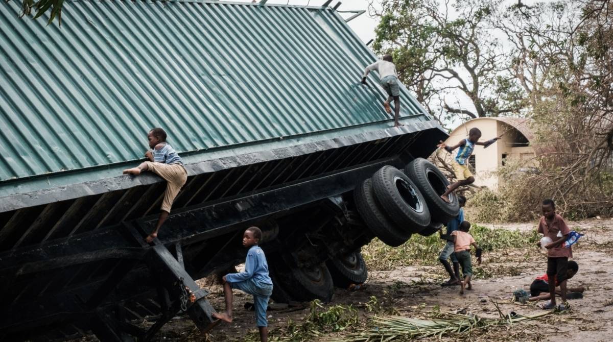 Crianças brincam em caminhão virado pelo ciclone Idai, em Beira, Moçambique