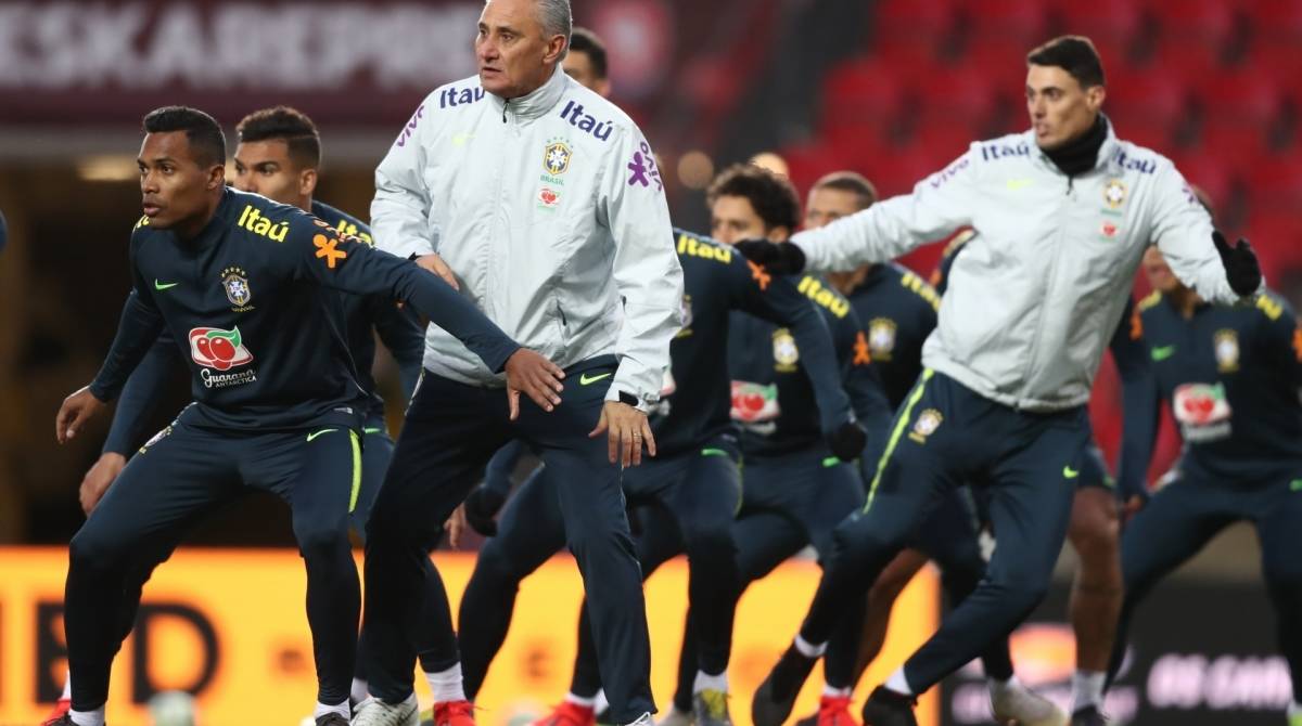 Tite, de branco, orienta o time no último treino para o jogo de hoje