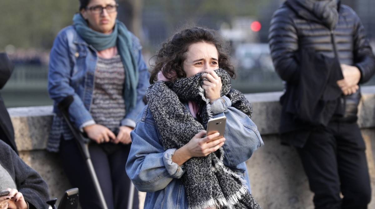 Pessoas observam a catedral de Notre-Dame em chamas, em Paris