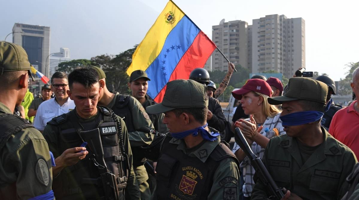Venezuelanos ao lado de membros das forças de segurança em Caracas 