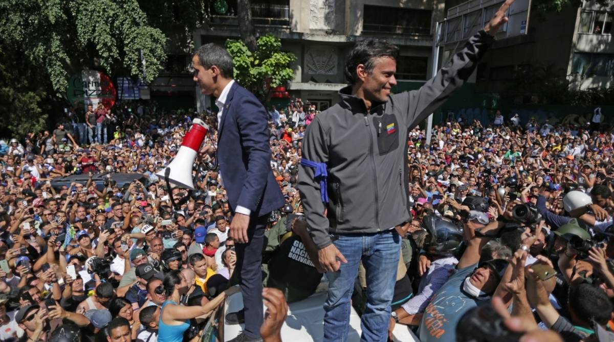 Venezuelan opposition leader and self-proclaimed acting president Juan Guaido (L) and high-profile opposition politician Leopoldo Lopez, who had been put under home arrest by Venezuelan President Nicolas Maduro's regime, greet supporters after being joined by members of the Bolivarian National Guard to oust Maduro, in Caracas on April 30, 2019. - Guaido -- accused by the government of attempting a coup Tuesday -- said there was "no turning back" in his attempt to oust President Nicolas Maduro from power. (Photo by Cristian HERNANDEZ / AFP)