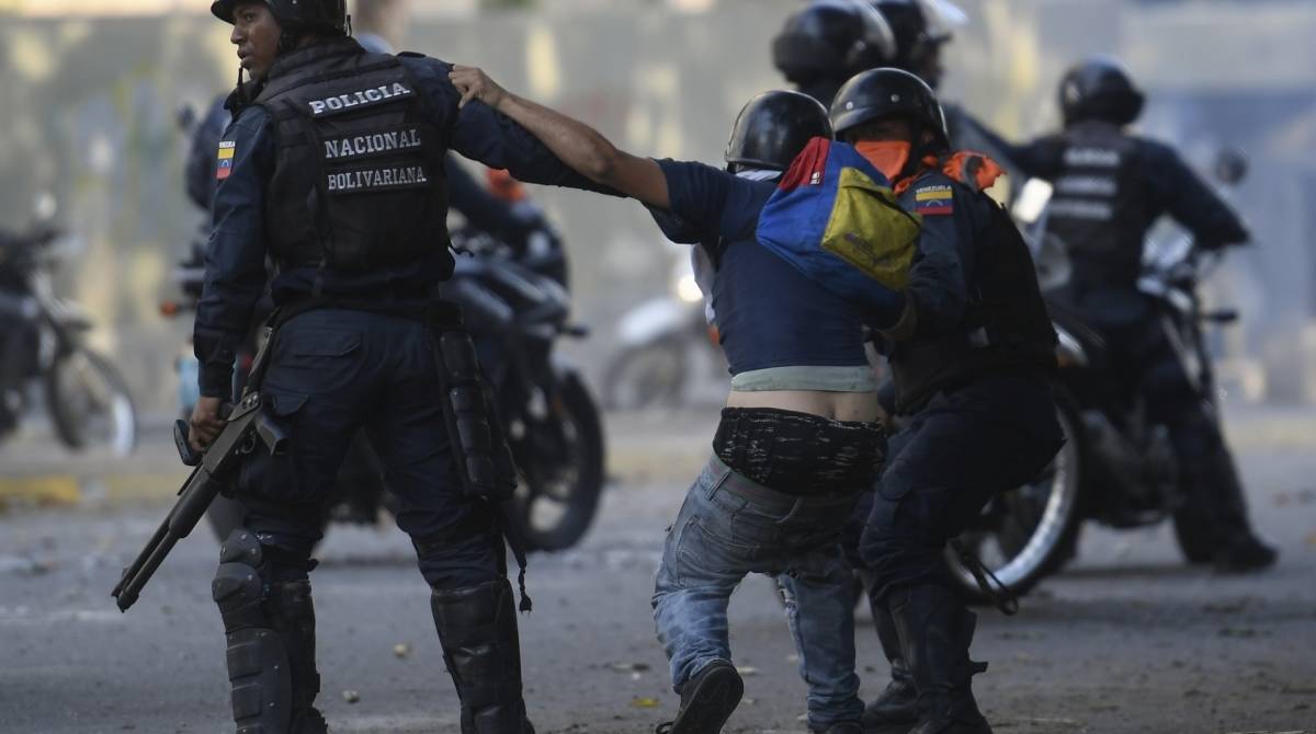 Um manifestante contra o governo é detido pelas forças de segurança durante confrontos com as forças de segurança em Caracas  - Federico Parra / AFP