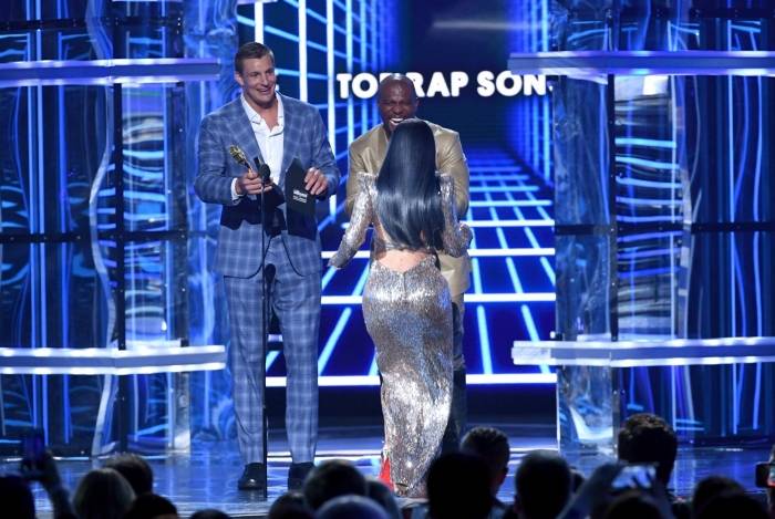 LAS VEGAS, NEVADA - MAY 01: (L-R) Rob Gronkowski and Terry Crews present the Top Rap Song award for 'I Like It' to Cardi B onstage during the 2019 Billboard Music Awards at MGM Grand Garden Arena on May 01, 2019 in Las Vegas, Nevada.   Kevin Winter/Getty Images for dcp/AFP
      Caption