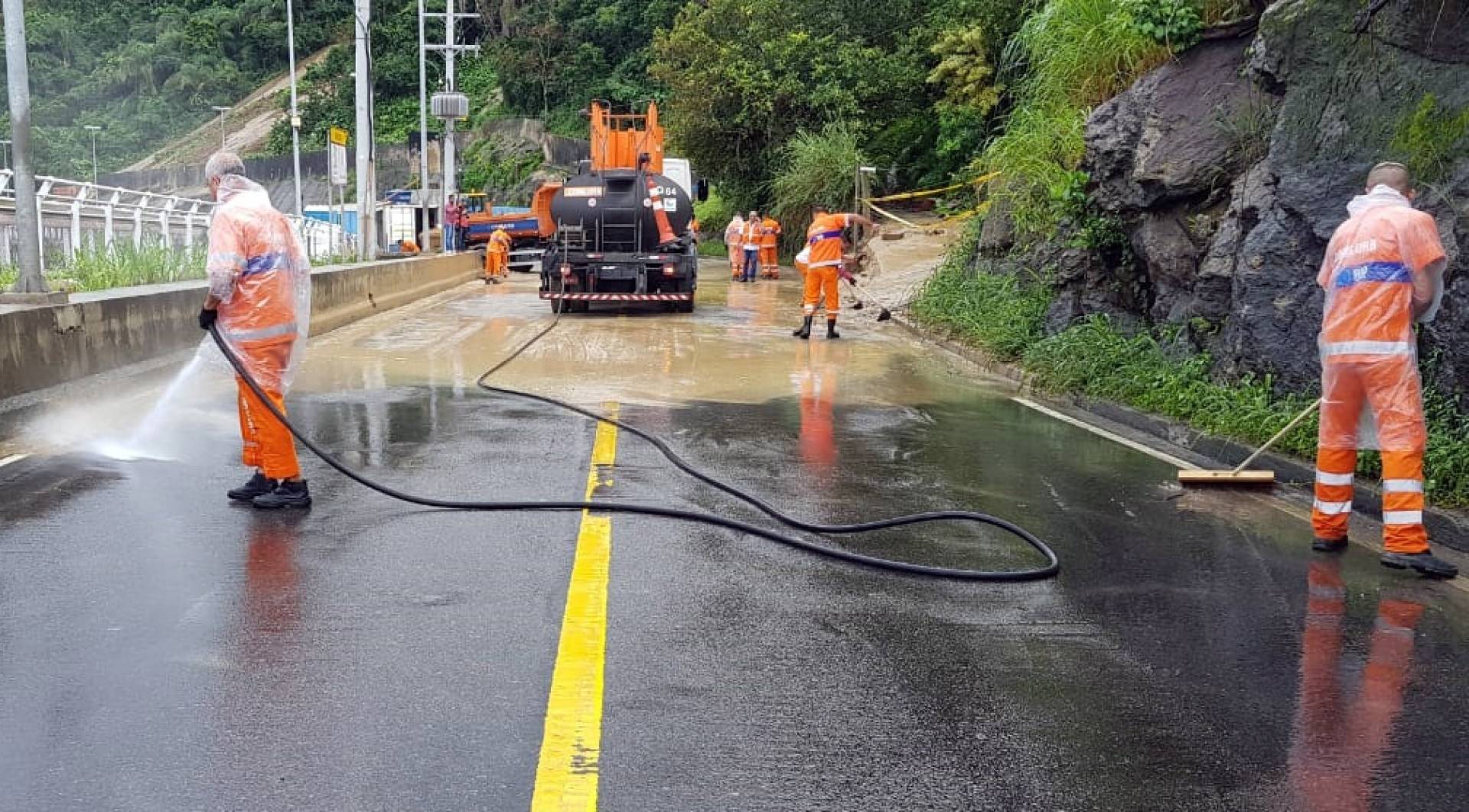 Agentes trabalham para a retirada da lama da pista