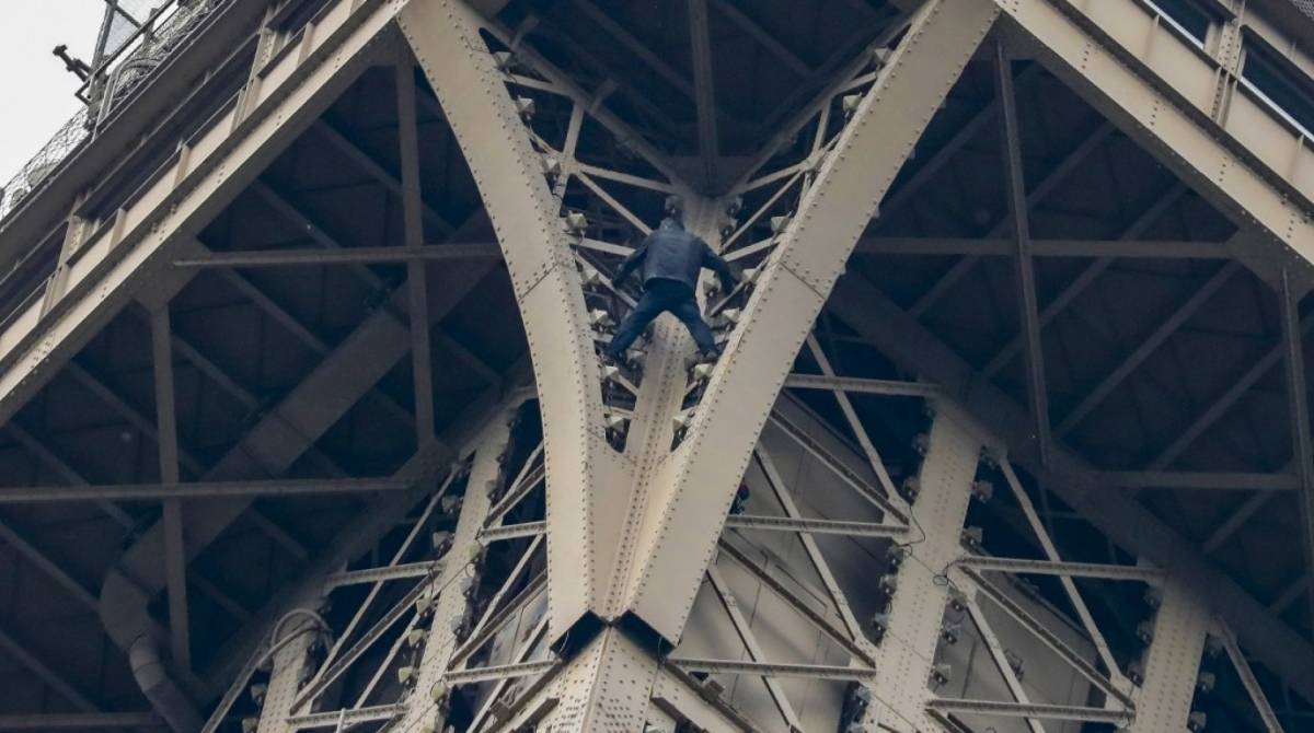 Um homem sobe ao topo da Torre Eiffel, em Paris, sem qualquer proteção
