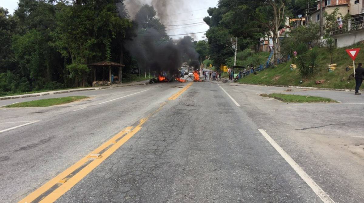 Moradores da comunidade da Lambicada, em Angra dos Reis, protestam na BR-101 com corpos na via