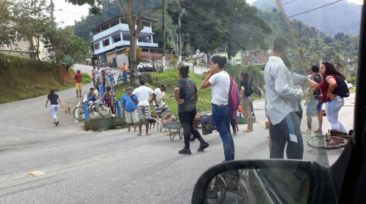Moradores da comunidade da Lambicada, em Angra dos Reis, protestam na BR-101 com corpos na via