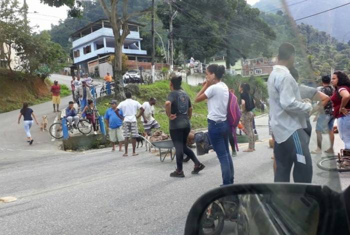 Moradores da comunidade da Lambicada, em Angra dos Reis, protestam na BR-101 com corpos na via