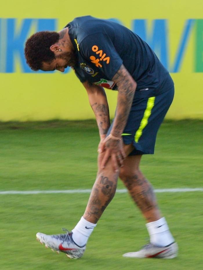 Com expressão de dor, Neymar leva as mãos ao joelho esquerdo