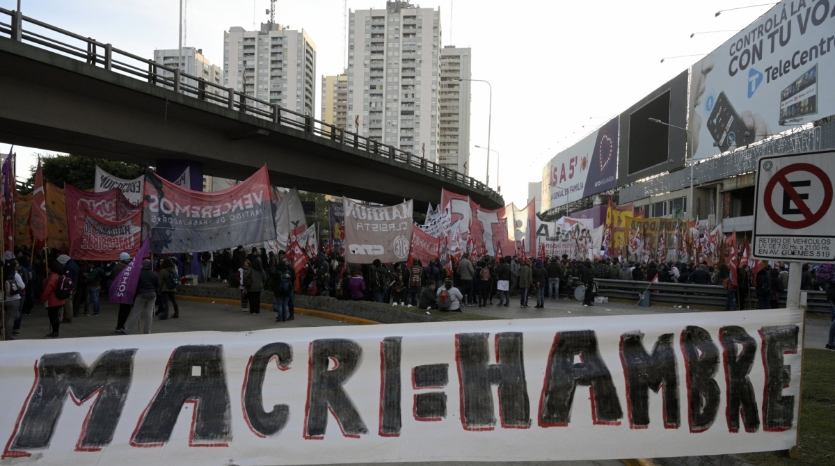 Membros de partidos de esquerda e organizações sociais exibem um cartaz com a inscrição 