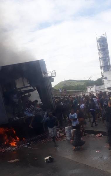 Pessoas entram em caminhão em chamas para retirar carga de cerveja