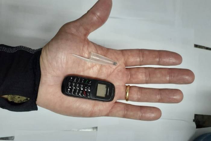 Mini aparelho celular em comparação com uma tampa de caneta