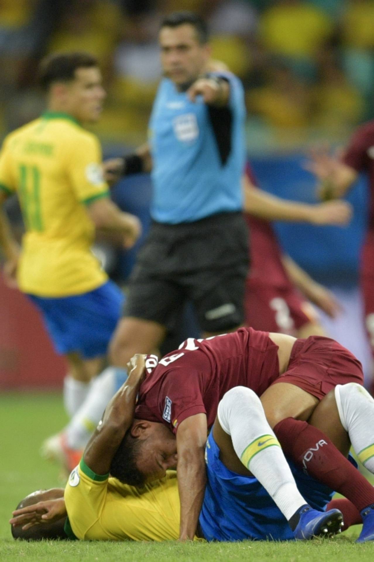 Venezuela's Arquimedes Figuera (top) and Brazil's Fernandinho react during their Copa America football tournament group match at the Fonte Nova Arena in Salvador, Brazil, on June 18, 2019