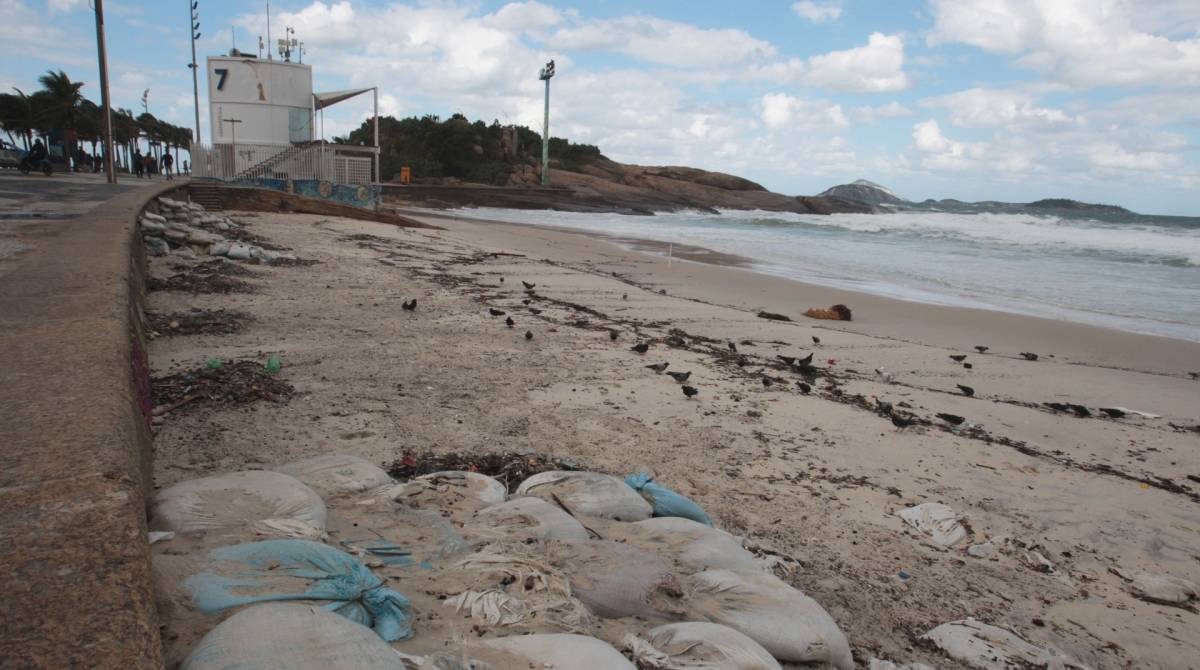 Cariocas e turistas aproveitam o fim de semana na praia mesmo com muito frio e chuva. Na foto, ressaca leva detritos e muita reia para o Arpoador.   