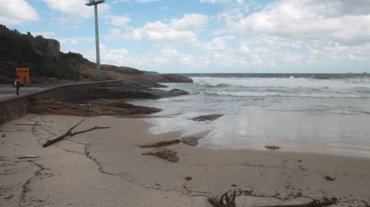 Cariocas e turistas aproveitam o fim de semana na praia mesmo com muito frio e chuva. Na foto, ressaca leva detritos e muita areia para o Arpoador.