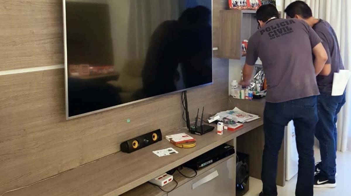 Dois policiais civis realizam buscas na casa do empresário suspeito - Divulgação / Polícia Civil
