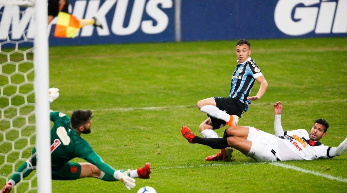 Atrasado, o zagueiro Henríquez não impede a finalização de Pepê, que marca para o Grêmio - MARCELO OLIVEIRA/AM PRESS & IMAGES/ESTADÃO CONTEÚDO