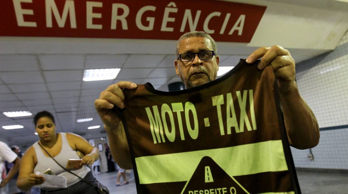 Eus&eacute;bio Gon&ccedil;alves de Assis, pai do mototaxista Davi Marques de Assis, segura o colete do filho - Luciano Belford/Ag&ecirc;ncia O Dia
