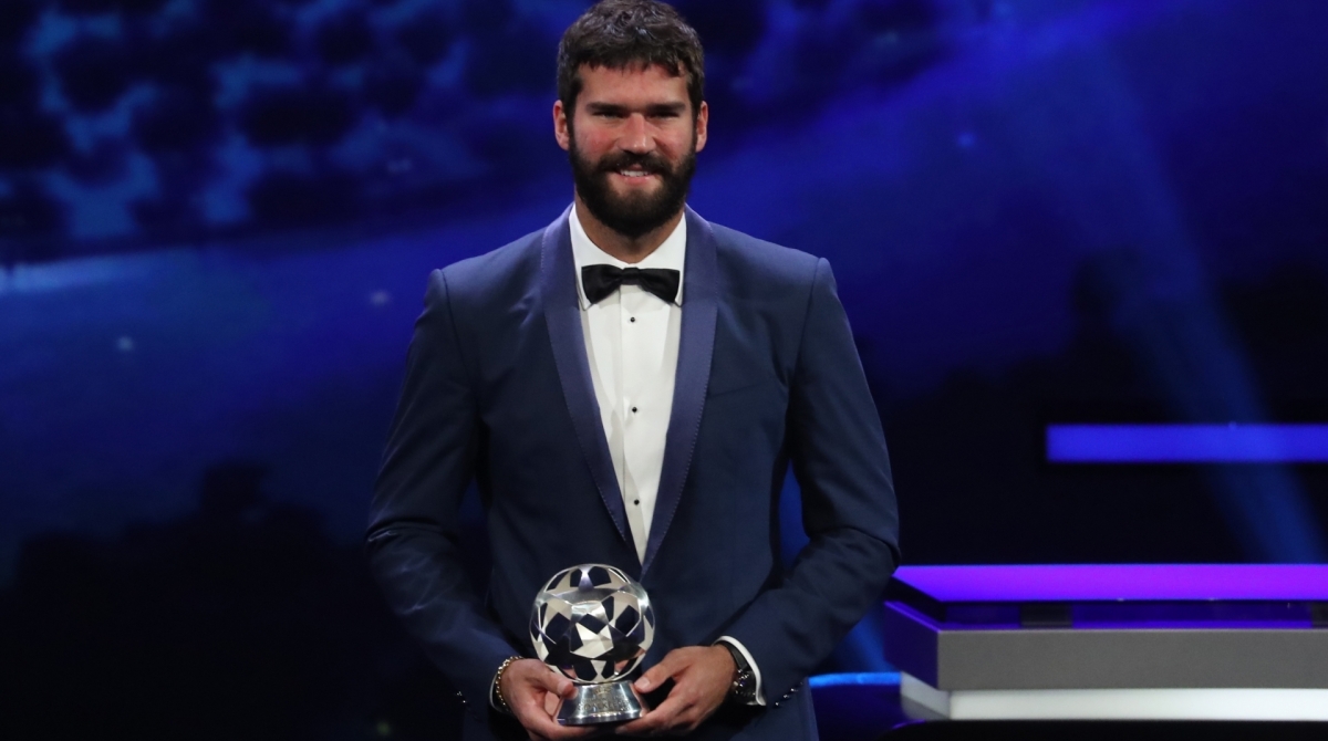 Brazilian goalkeeper Alisson Becker poses with his trophy of UEFA Goalkeeper of the Year during the UEFA Champions League football group stage draw ceremony in Monaco on August 29, 2019. (Photo by Valery HACHE / AFP)