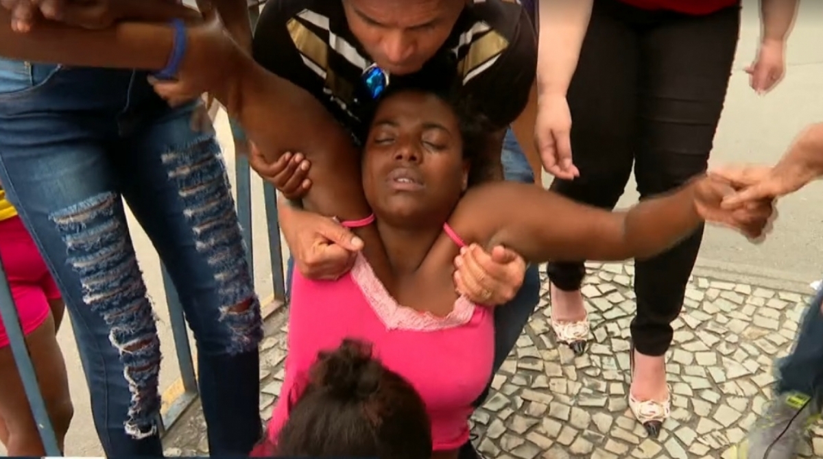 Mãe da menina Lauane desmaia na porta do Hospital Getúlio Vargas, para onde a criança foi levada - Reprodução de TV