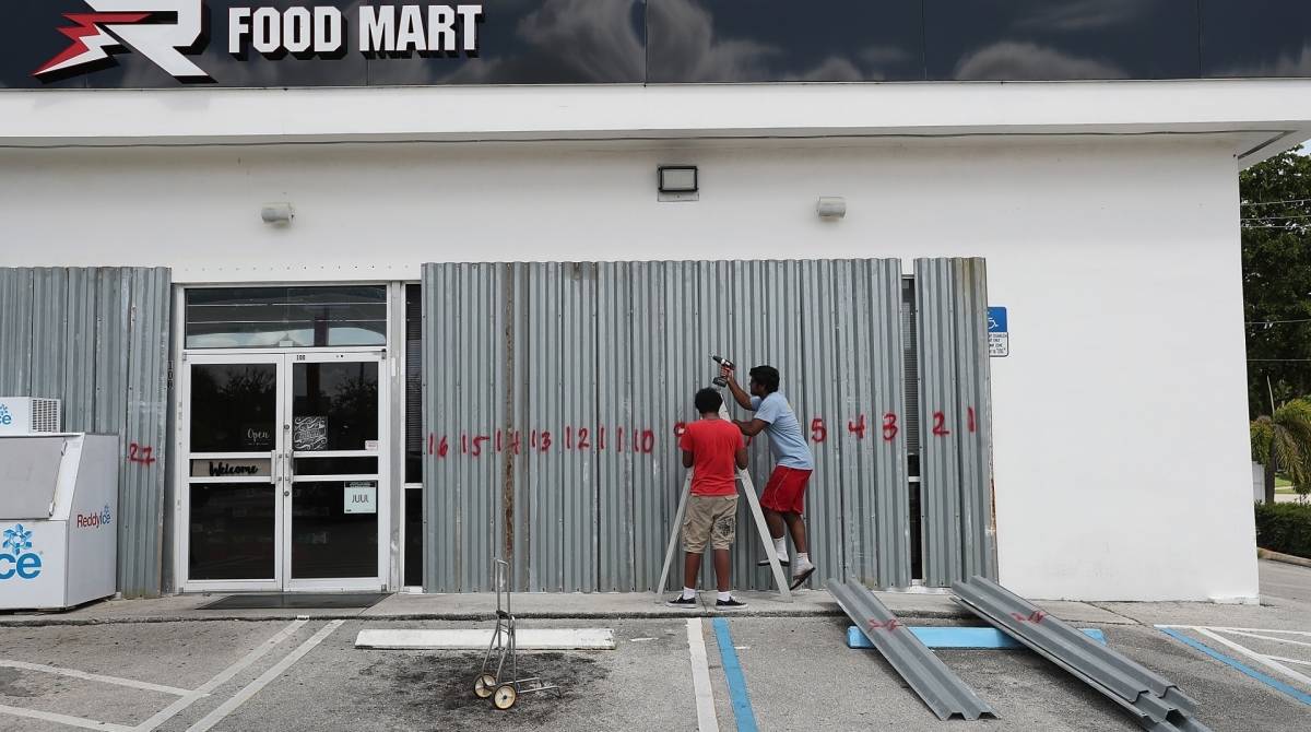 Moradores reforçavando a proteção de vitrines de lojas - AFP