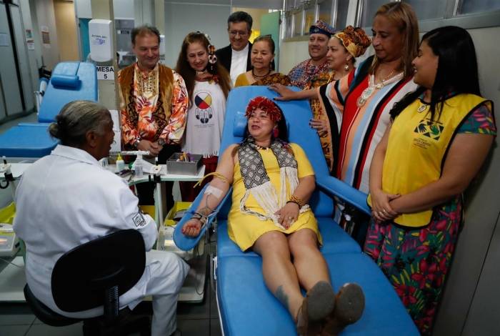 Na foto, a indÃgena Papiõn faz sua doação com vários religiosos