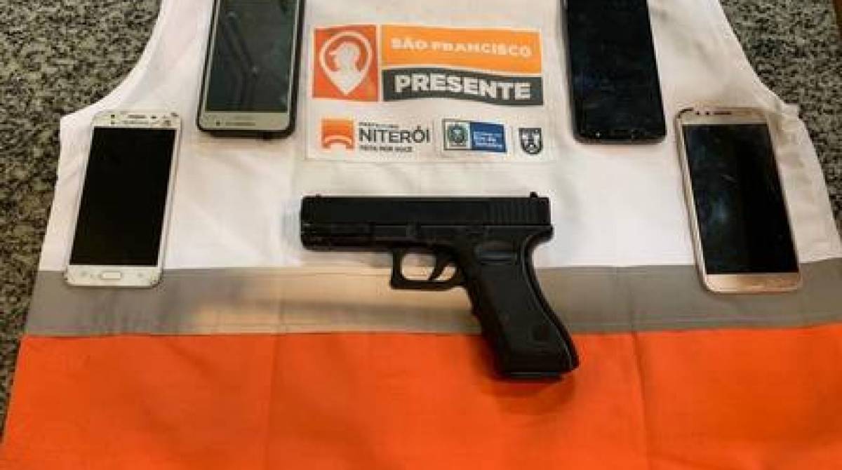 Foram apreendidos quatro celulares e um simulacro de arma