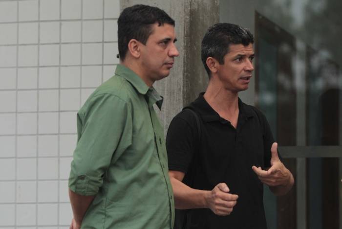 Jorge Baía (camisa verde) e Janilson Baía foram ao IML para liberar o corpo do irmão, o pedreiro José Pio Baía Junior, morto enquanto trabalhava na Vila Kennedy, Zona Oeste do Rio 
