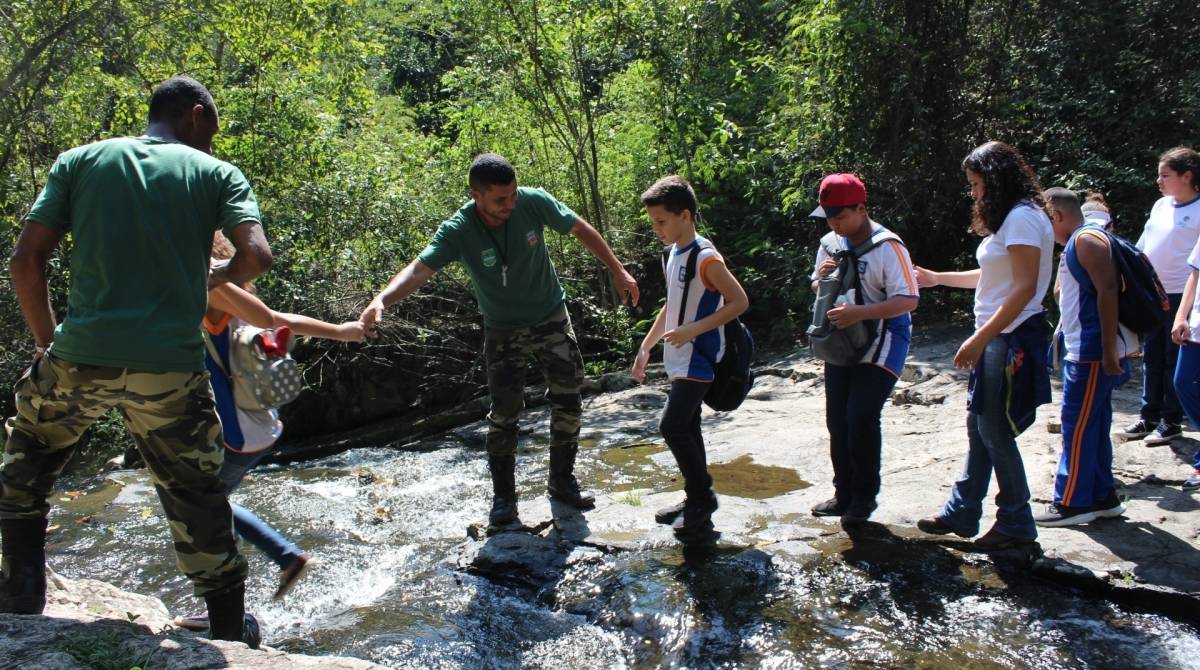 Os guardas ambientais ajudaram as crianças a passarem em locais mais escorregadios