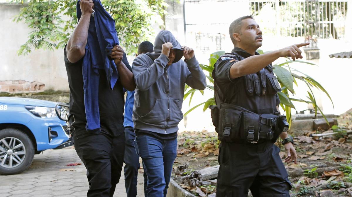 Escondendo o rosto, policiais que estavam de patrulha no Alemão chegam à DH para depor - Reginaldo Pimenta